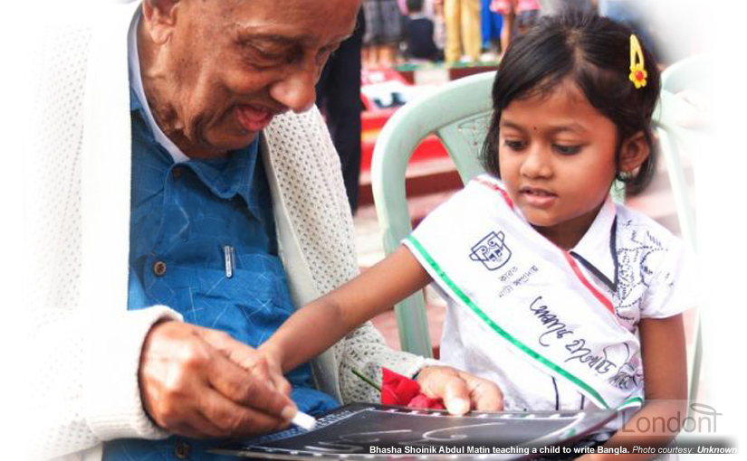 Abdul Matin with little girl writing Bengali on chalkboard